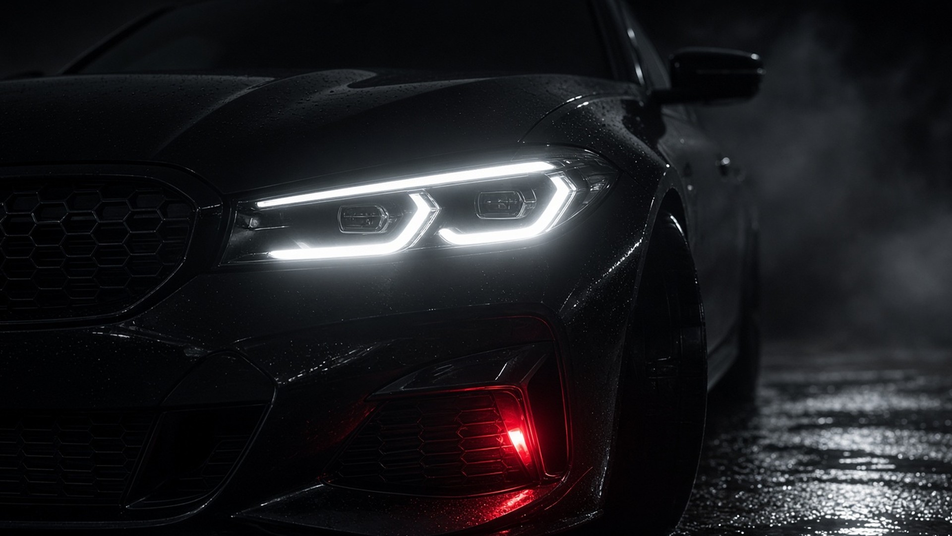 Black sedan headlights on wet asphalt at night